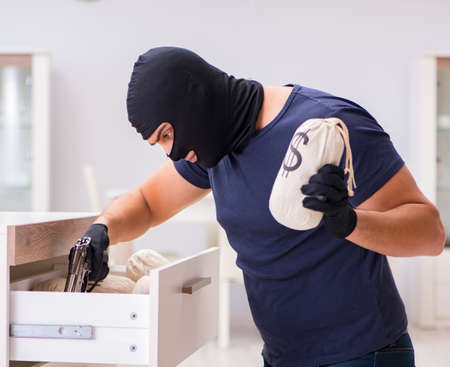 Robber wearing balaclava stealing valuable thingsの写真素材