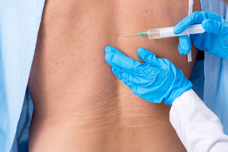 Young injured man visiting female doctor chiropractorの写真素材