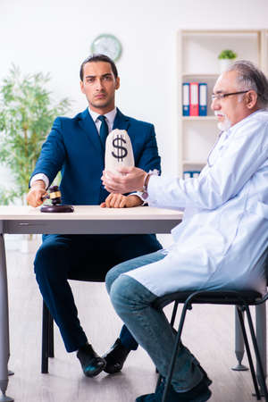 Male doctor in courthouse meeting with lawyerの写真素材