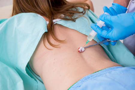 Young injured woman visiting male doctor chiropractor