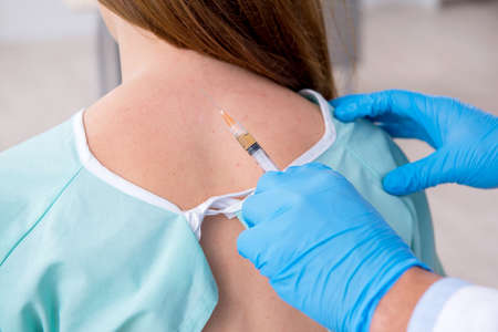 Young injured woman visiting male doctor chiropractorの写真素材