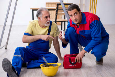 Two contractors in first aid conceptの写真素材