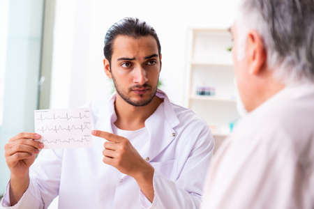 Old man visiting young male doctor cardiologistの写真素材