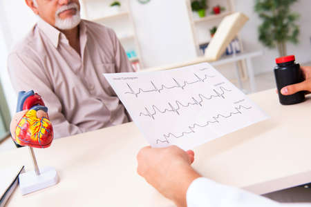 Old man visiting young male doctor cardiologist