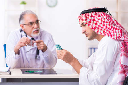 Young male arab visiting experienced male doctorの写真素材
