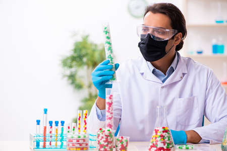 Young male chemist in drug synthesis concept