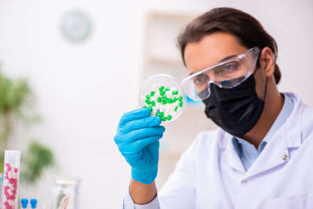 Young male chemist in drug synthesis conceptの写真素材