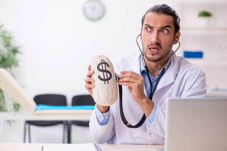 Young handsome male doctor working in the clinicの写真素材