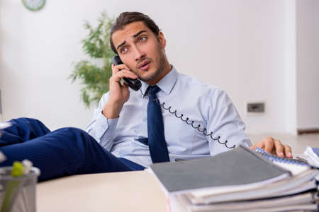 Young male businessman employee unhappy with excessive workの写真素材