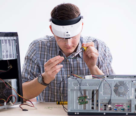 The young technician repairing computer in workshopの写真素材