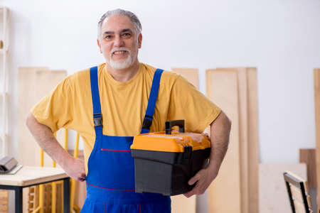 Old male carpenter working in workshopの写真素材