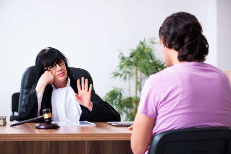 Young man consulting with judge on litigation issueの写真素材