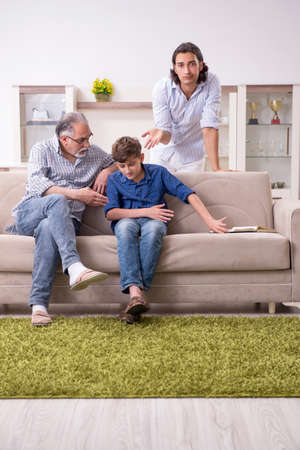 Boy and his father and his grandfother indoorの写真素材