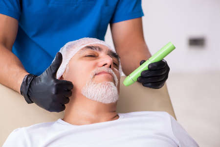 Old man visiting male doctor for plastic surgeryの写真素材