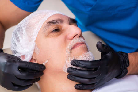 Old man visiting male doctor for plastic surgeryの写真素材