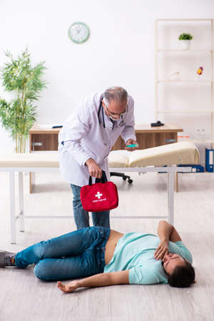 Experienced doctor and male patient in first aid concept