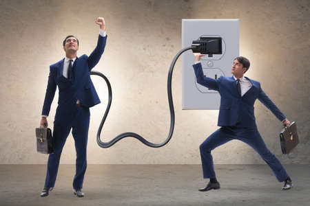 Businessman being powered by electricity and plugの写真素材
