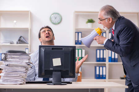 Old boss and young male employee in the officeの写真素材