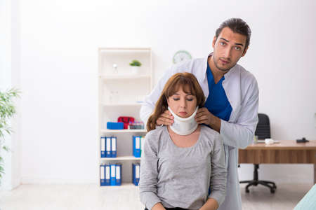 Young injured woman visiting doctor traumatologistの写真素材