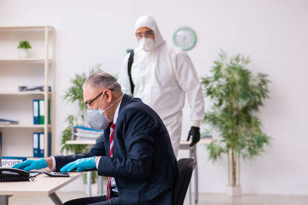 Old employee and young contractor in coronavirus conceptの写真素材