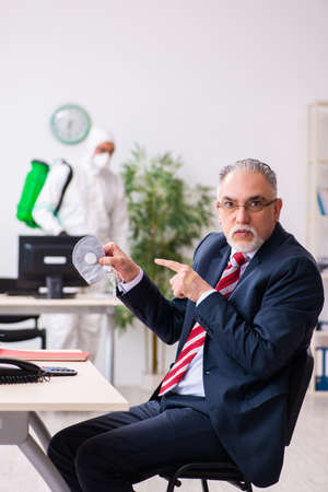 Old employee and young contractor in coronavirus conceptの写真素材