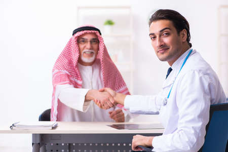 Old male arab visiting young male doctorの写真素材