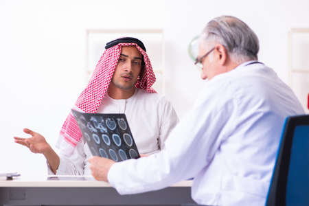 Young male arab visiting experienced male doctorの写真素材