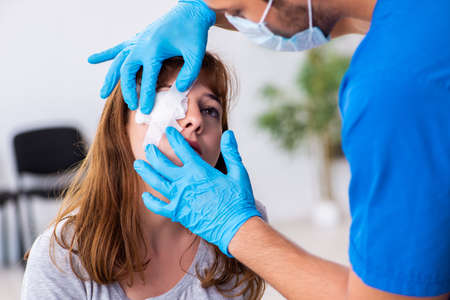 Young head injured woman visiting young male doctor