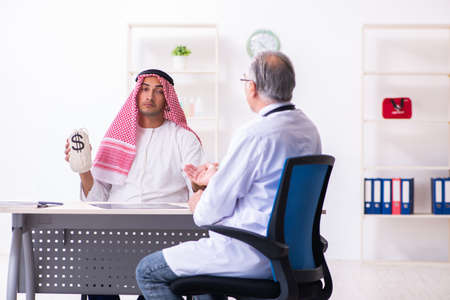 Young male arab visiting experienced male doctorの写真素材