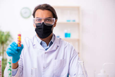 Young male chemist in drug synthesis concept