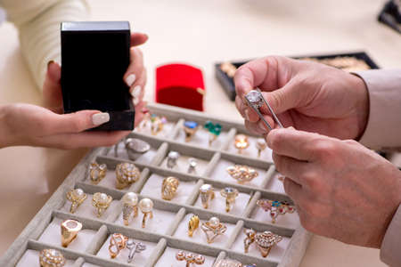 Young woman visiting old male jewelerの写真素材