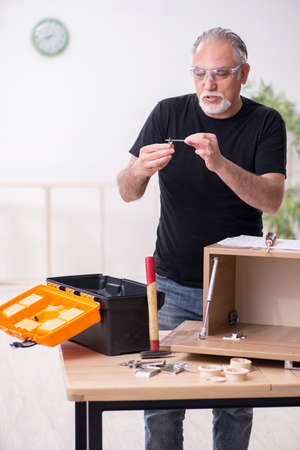 Old male carpenter working indoorsの写真素材