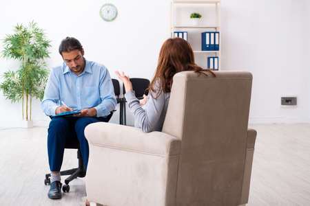 Pregnant woman visiting young male psychologistの写真素材