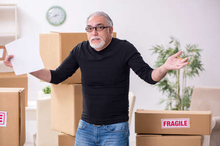 Old male professional mover doing home relocationの写真素材
