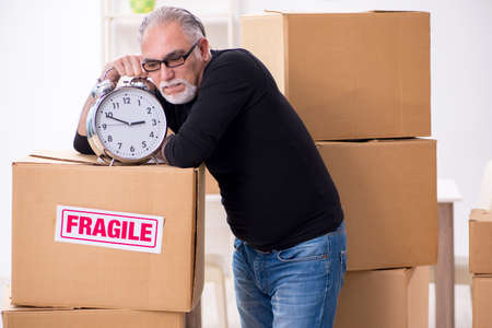 Old male professional mover doing home relocationの写真素材