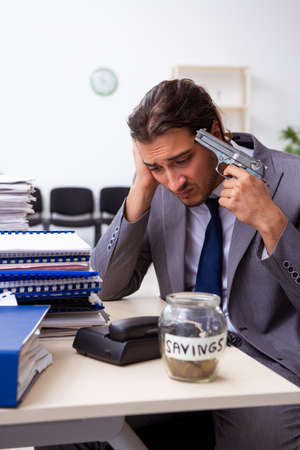 Young male employee unhappy with excessive workの写真素材