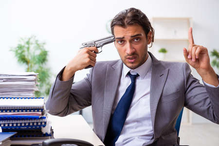 Young male employee unhappy with excessive workの写真素材