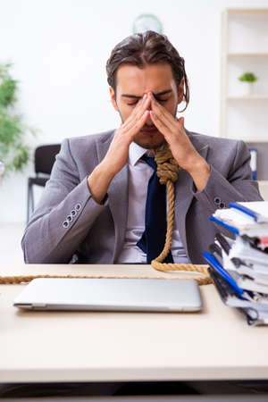 Young male employee unhappy with excessive workの写真素材