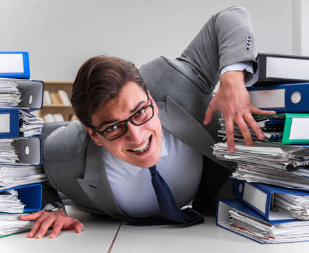 Businessman under stress due to excessive workの写真素材