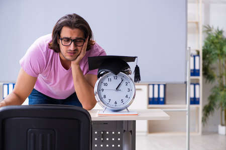 Young male student in time management conceptの写真素材