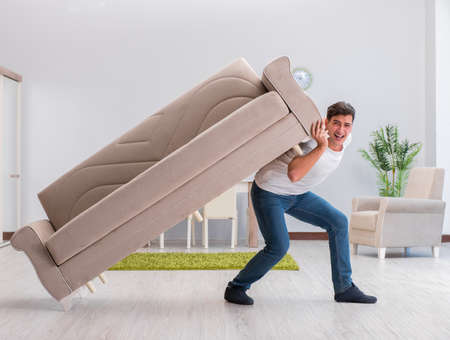 Man moving furniture at homeの写真素材
