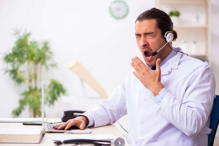 Young doctor listening to patient during telemedicine sessionの写真素材