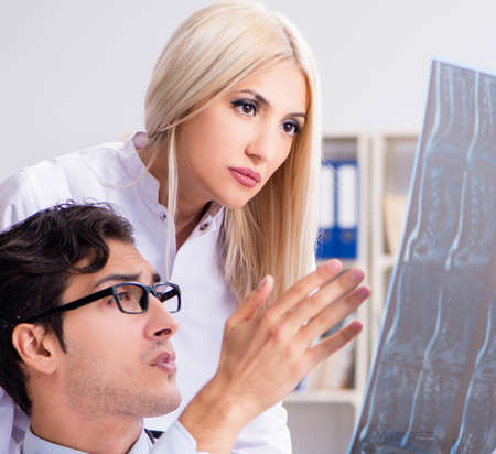 Two doctors examining x-ray images of patient for diagnosis