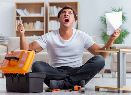 Man assembling furniture at homeの写真素材