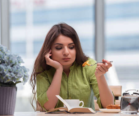 Young girl having breakfast at homeの写真素材