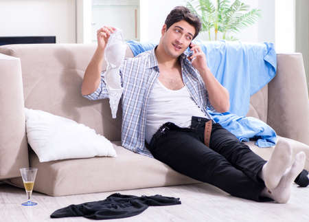 Man with mess at home after house partyの写真素材