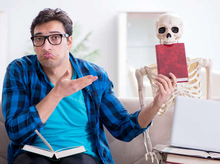 Student studying with skeleton preparing for examsの写真素材