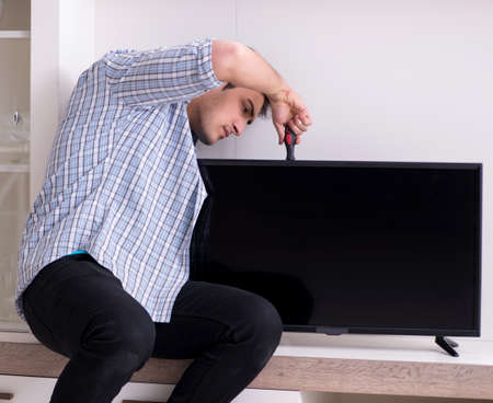 Man repairing broken tv at homeの写真素材