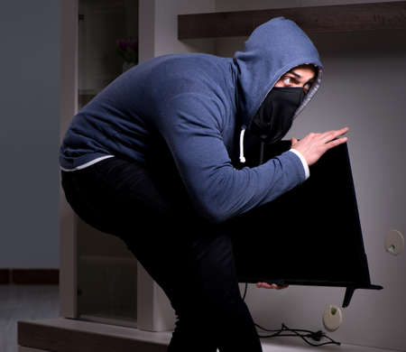 Burglar thief stealing tv from apartment houseの写真素材