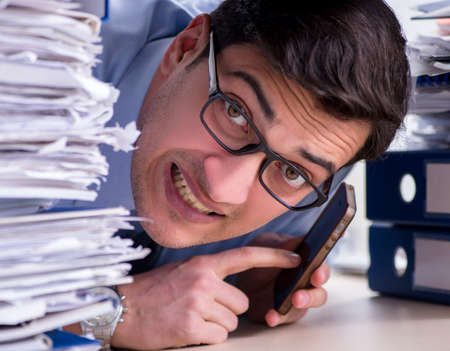 Extremely busy businessman working in office